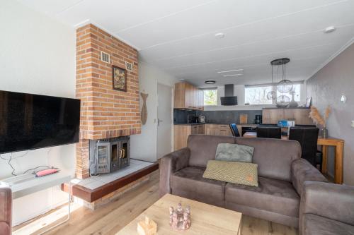 a living room with a couch and a fireplace at Parel 164 in Den Burg