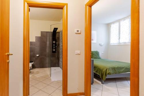 Habitación con cama y baño con espejo. en Lake And Mountain Comfort Flat, en Lecco