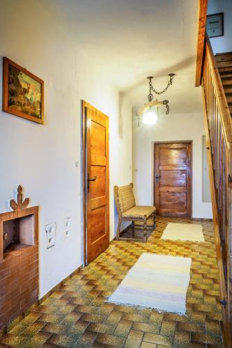 a living room with a wooden door and a chair at Holiday Home Glatzbichl by Interhome in Pfarrwerfen