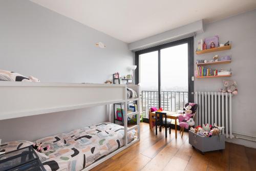 une chambre avec un lit superposé et un bureau dans l'établissement Top floor with Eiffel Tower view and roof top, à Paris