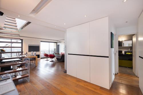 un salon avec des armoires blanches et une salle à manger dans l'établissement Top floor with Eiffel Tower view and roof top, à Paris