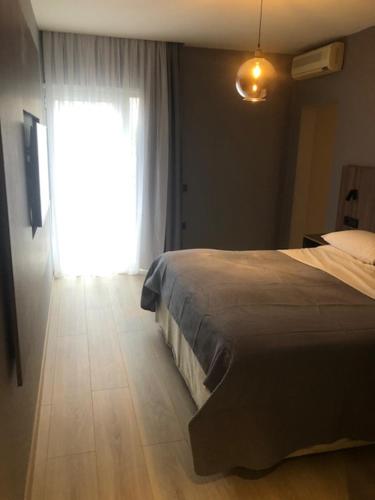 a bedroom with a bed and a large window at Evridiki in Kilkís