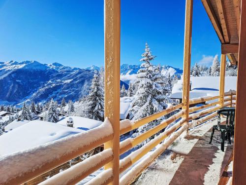 a snow covered porch with a view of mountains at Holiday Home Midat soleil by Interhome in Verbier