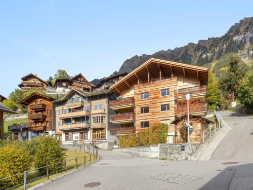 a large wooden building with mountains in the background at Apartment Am Acher II Apt- F by Interhome in Wengen