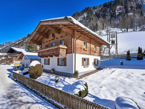 a wooden house in the snow with a fence at Holiday Home Wallner by Interhome in Fusch an der Glocknerstraße