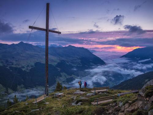 two people standing on top of a mountain with a cross at Apartment Prem by Interhome in Kappl