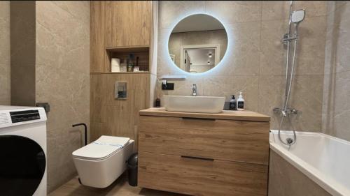 a bathroom with a sink and a toilet and a mirror at Light 2-кімн Нова стильна квартира на Київській in Ternopilʼ