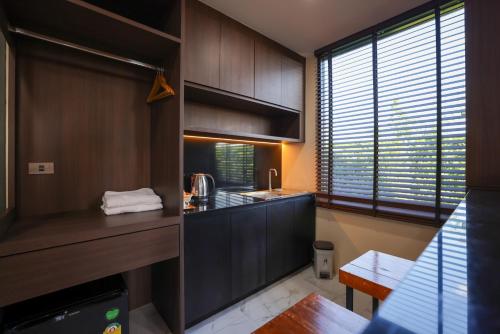 a kitchen with wooden cabinets and a counter top at Momtikcamp Hotel in Ban Nong Muang