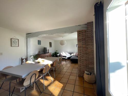 - une salle à manger et un salon avec des tables et des chaises dans l'établissement Le Saule, à Biganos