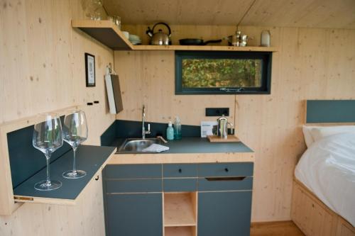 une petite cuisine avec un évier et deux verres à vin dans l'établissement Sleep Space 4 - Green Tiny Spot Friesland, à Schortens