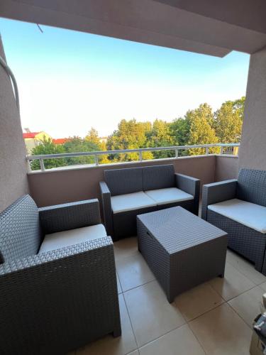 a balcony with chairs and tables and a view of trees at Downtown Apartment in Strumica