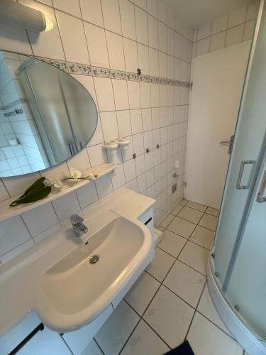 a white bathroom with a sink and a mirror at Strandgut in Fehmarn
