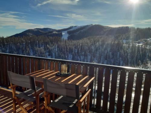 a wooden table and chairs on a deck with a view at Alpen Panoramic in Péone