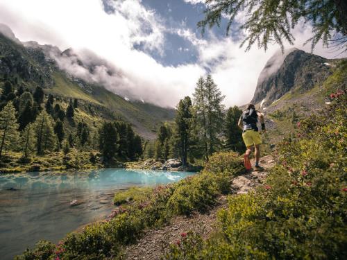 a man walking along a trail next to a river at Apartment Aurora Apartment Top I by Interhome in Kappl
