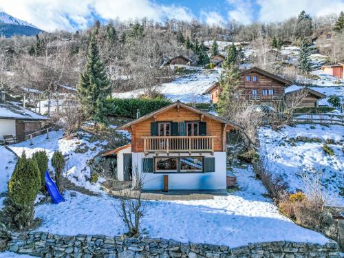 a house with a deck in the snow at Chalet Chalet Grepon by Interhome in Saclentse
