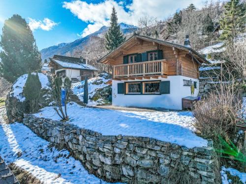 a log cabin in the snow with a stone wall at Chalet Chalet Grepon by Interhome in Saclentse
