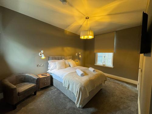 a bedroom with a bed and a chair at Sandbed in Hawick