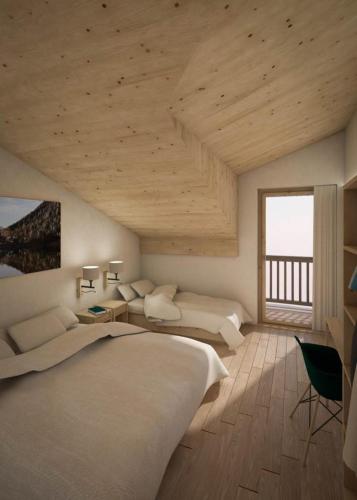 a bedroom with two beds and a large window at Le Rendez-vous in Champex