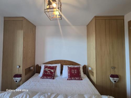 a bedroom with a large bed with red pillows at Essert A14 in Champoussin
