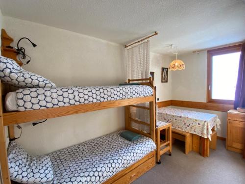 a bedroom with two bunk beds and a window at Chez mon Grand-père in Valmorel