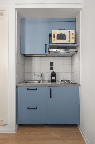 a kitchen with a sink and a microwave at Casa del Sol Suites in Rhodes Town