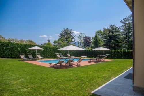 a group of chairs and umbrellas next to a pool at Villa Il Portico in Verbania