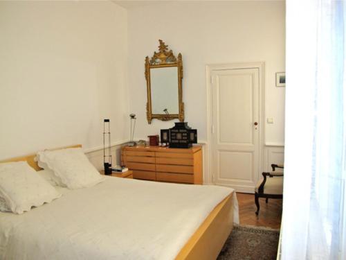 - une chambre avec un lit, un miroir et une commode dans l'établissement T3 HYPERCENTRE Jardin Public, à Bordeaux