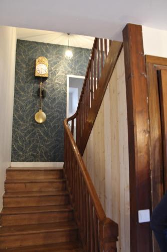a staircase in a house with a clock on the wall at Maison Guchan Saint Lary 2 chambres in Guchan