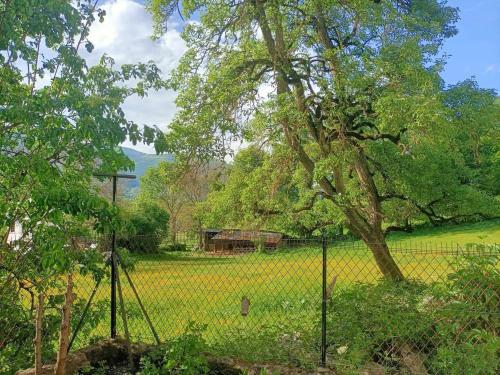 a fence in front of a field with a tree at Maison Guchan Saint Lary 2 chambres in Guchan