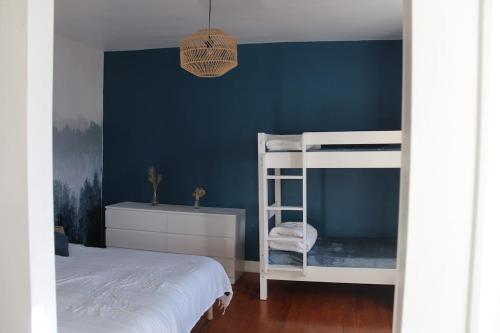 a bedroom with blue walls and a bunk bed at Maison Guchan Saint Lary 2 chambres in Guchan