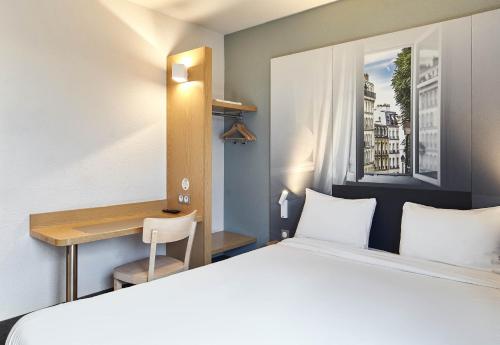 a hotel room with a bed and a desk at B&B HOTEL Paris Le Bourget in Le Bourget