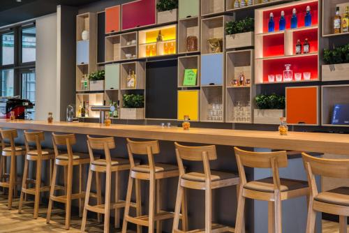 a bar at a restaurant with stools at IntercityHotel Wiesbaden in Wiesbaden
