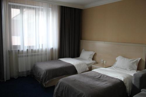 a hotel room with two beds and a window at King Hotel Astana in Astana