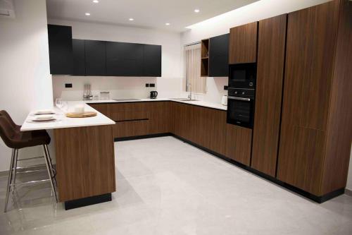 a kitchen with wooden cabinets and a white counter top at Flat 2, stay close to Countryside & Beaches in Mġarr