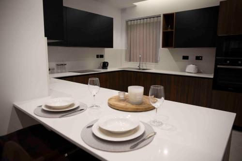 a kitchen with a table with plates and wine glasses at Flat 2, stay close to Countryside & Beaches in Mġarr