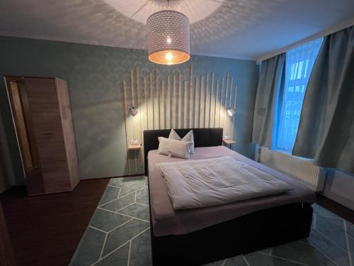 a bedroom with a large bed with a large window at Hotel Am Vogelsang in Gevelsberg