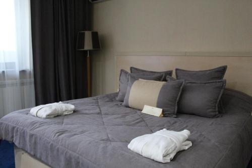 a bed with two white towels on top of it at King Hotel Astana in Astana