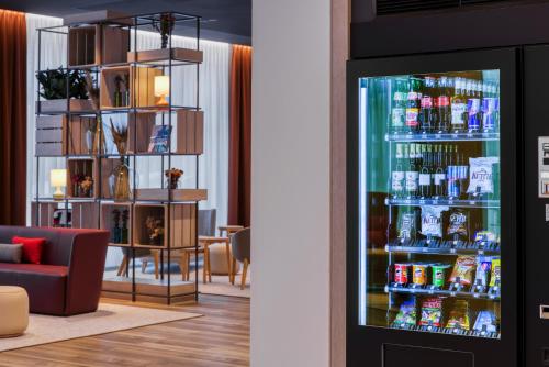 a room with a bar with a refrigerator at IntercityHotel Wiesbaden in Wiesbaden