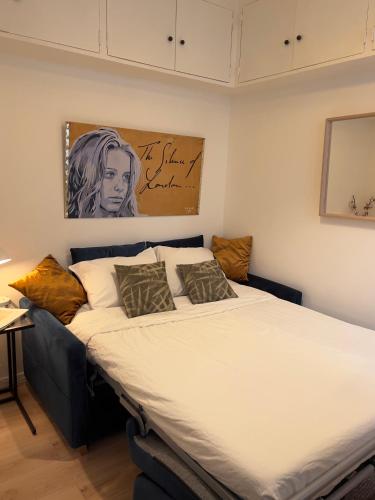 un lit dans une chambre avec un tableau sur le mur dans l'établissement Studio Paris Central, à Paris