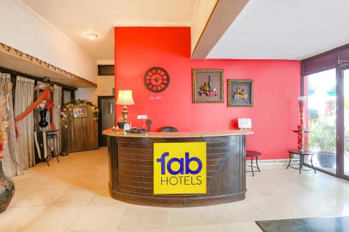 a bar in a room with a red wall at FabHotel Pulse Impulse in New Delhi