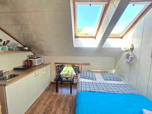 a small kitchen with a bed in a tiny house at 6B Meridian studio with Sauna in Klaipėda
