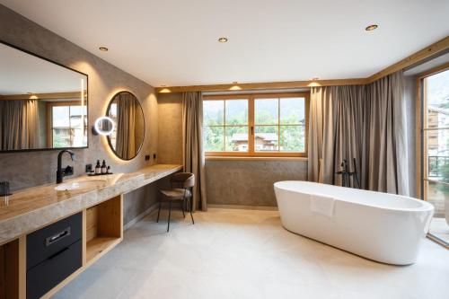 baño con bañera grande y espejo grande en NOVA Moments Boutique Hotel, en Pertisau