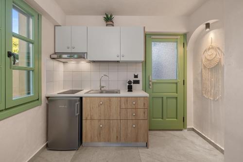 a kitchen with a sink and a green door at Casa del Sol Suites in Rhodes Town