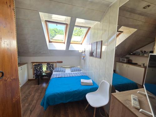 a bedroom with a blue bed in a attic at 6B Meridian studio with Sauna in Klaipėda