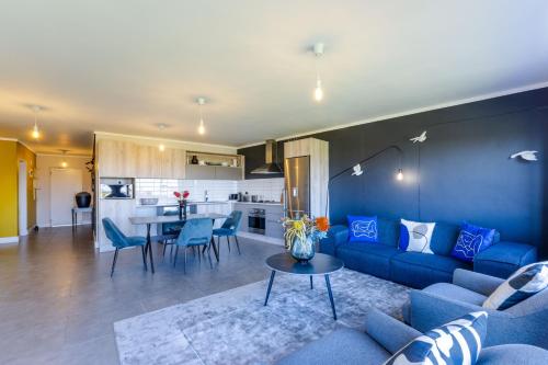 a living room with a blue couch and a table at Waters Edge Apartments in Cape Town