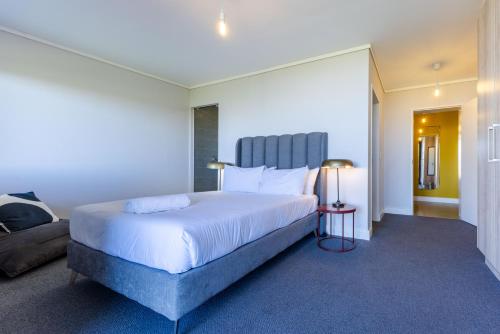 a bedroom with a large bed and a couch at Waters Edge Apartments in Cape Town