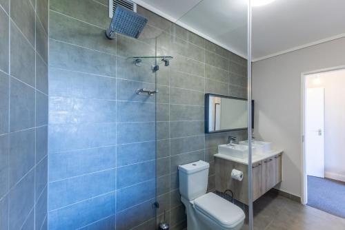 a bathroom with a toilet and a sink at Waters Edge Apartments in Cape Town
