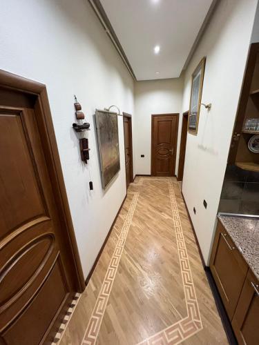 a hallway with white walls and wooden floors at Cozy apartment in the heart of Baku in Baku