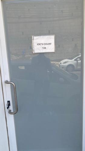 a sign on the door of a garage at Joes Court in Misraħ Il-Barrieri