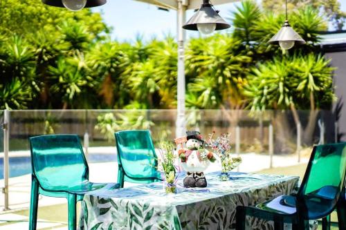 a table with blue chairs and a vase on it at Prime Glen Huntly Beauty - 4BR Family Home w pool in Melbourne